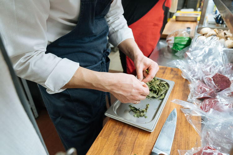 Midsection of man preparing food in kitchen