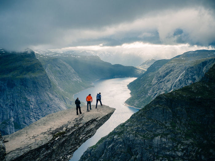 People on snowcapped mountains against sky