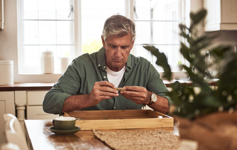 Portrait of senior man using mobile phone at home