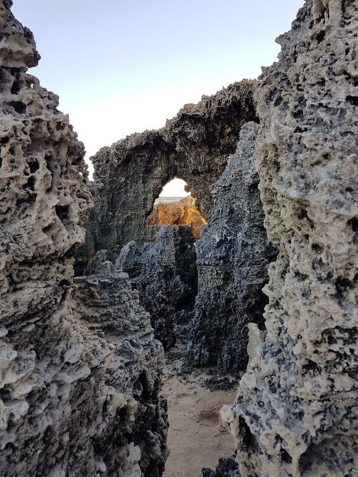 LOW ANGLE VIEW OF CAVE AGAINST SKY