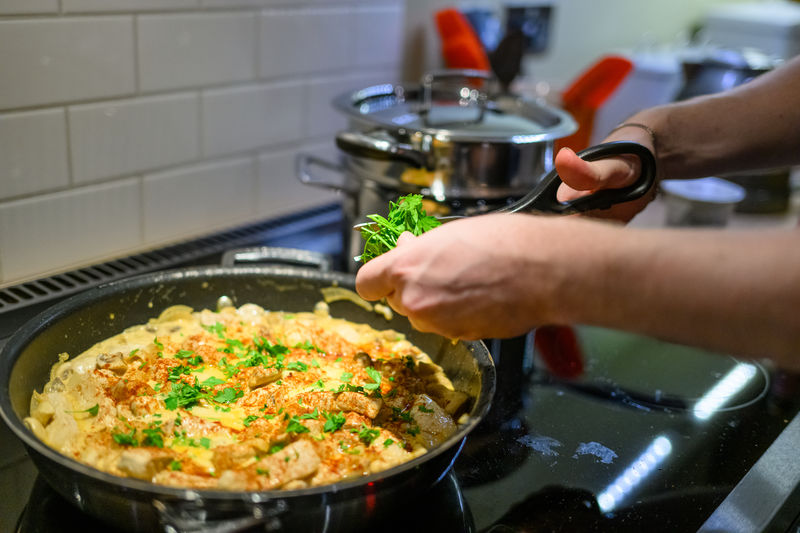 Cropped hand preparing food in kitchen