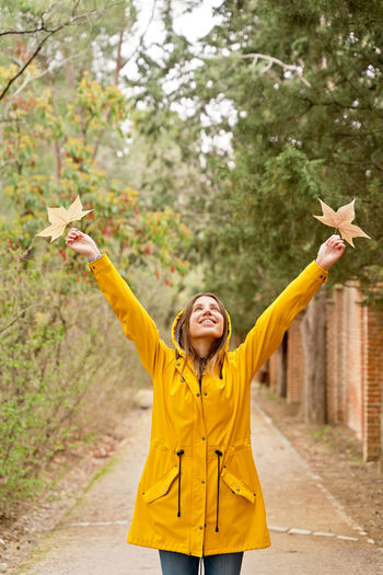 Portrait of young woman with arms outstretched standing on snow