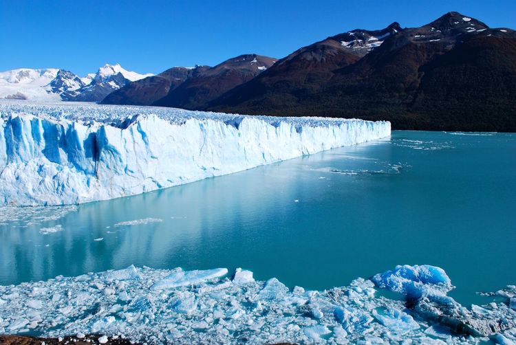 Glaciers melting in river against mountains during winter