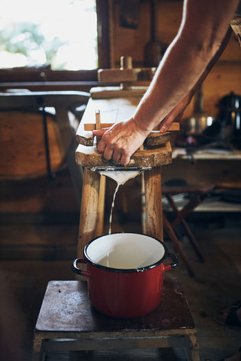 Cheese making. person making cottage cheese using cheese press and traditional old technique