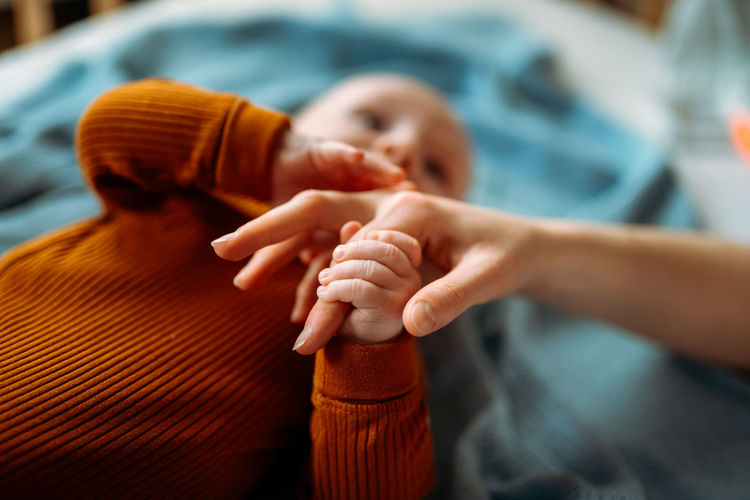 Baby toddler holding mother's hand. holding hand of newborn child