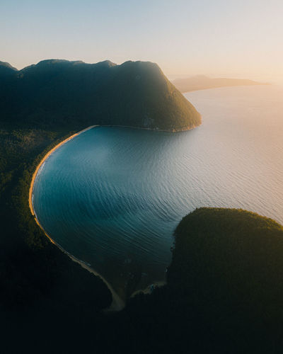 High angle view of sea against clear sky during sunset