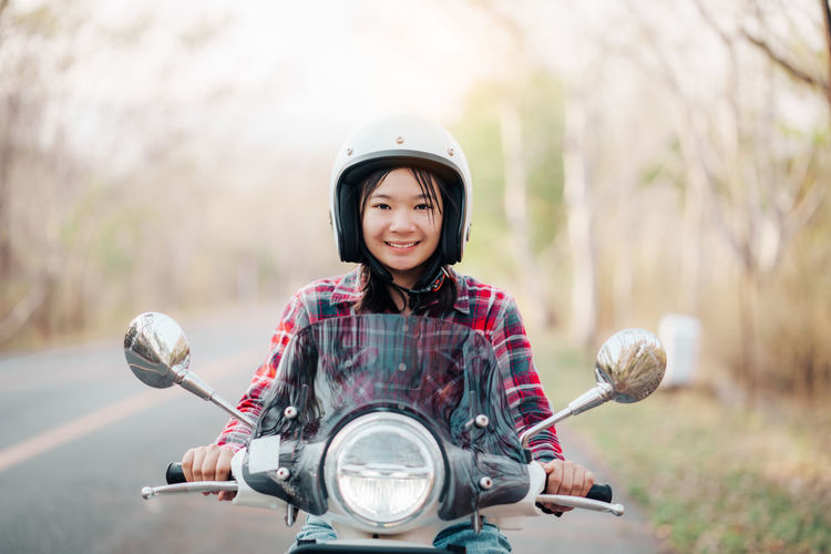 Portrait of young woman riding scooter