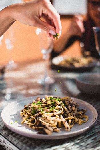 Close-up of person preparing food in plate