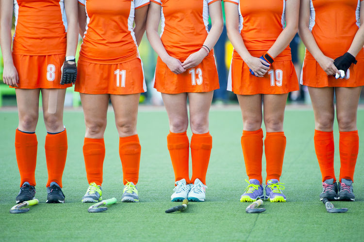 Low section athletes wearing uniform standing on hockey field