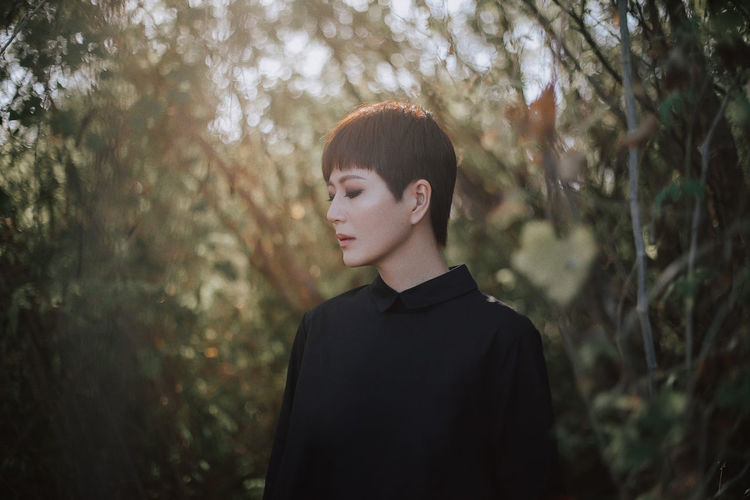Woman standing against trees