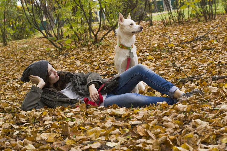 One teenage girl lying on ground with dog 
