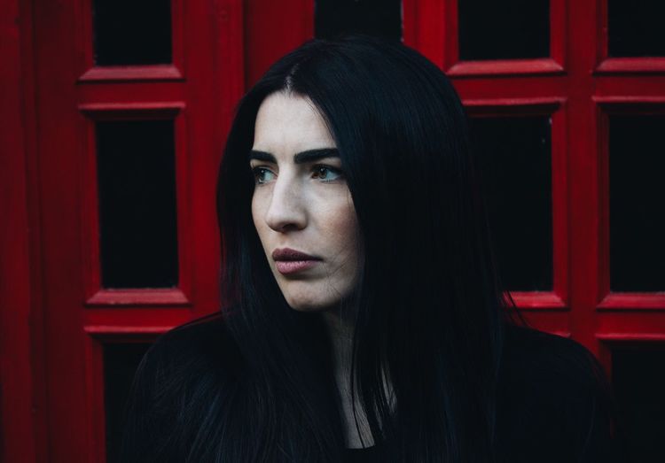Close-up of young woman against telephone booth