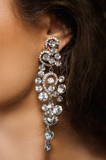 Ear and beautiful big earring with a lot of gemstones
