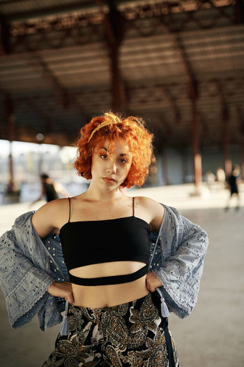 Young alternative redhead girl posing in a hangar