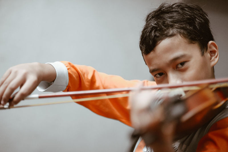 Portrait of boy playing violin at home