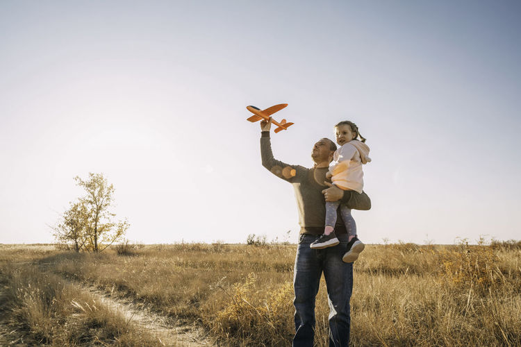 Father and child having fun outdoors. dad and daughter together, let an airplane into the sky