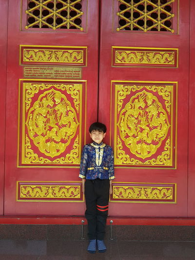 Full length of boy standing on entrance door
