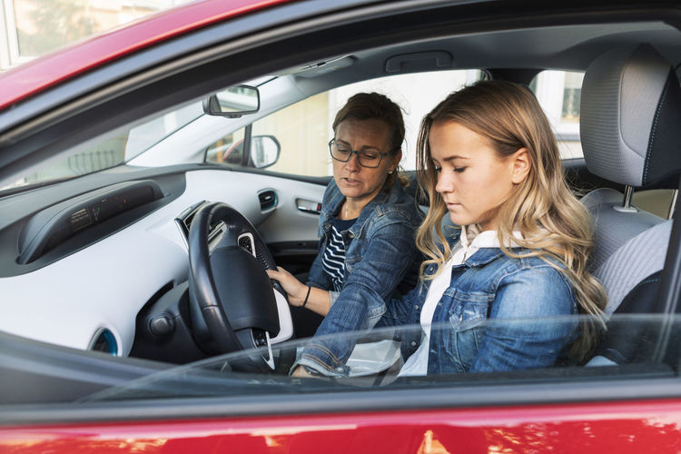 Mother teaching daughter driving during weekend