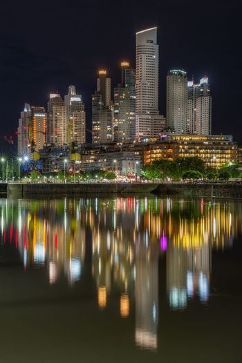 Reflection of illuminated buildings on lake at night