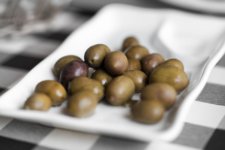High angle view of olives in plate on table