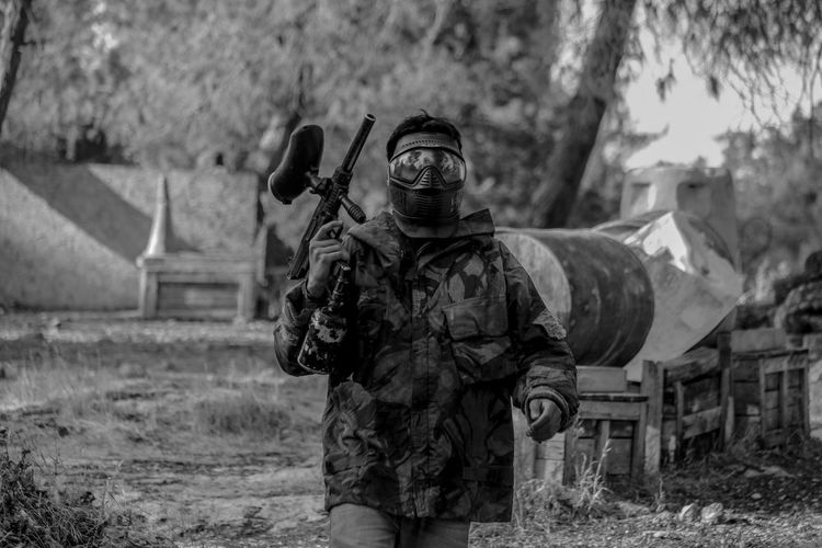 Man in camouflage clothing with paintball gun
