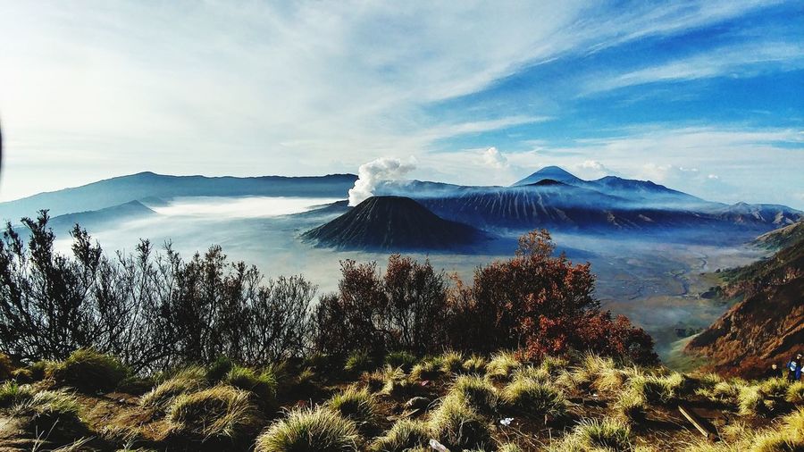 Scenic view of volcanic landscape against cloudy sky
