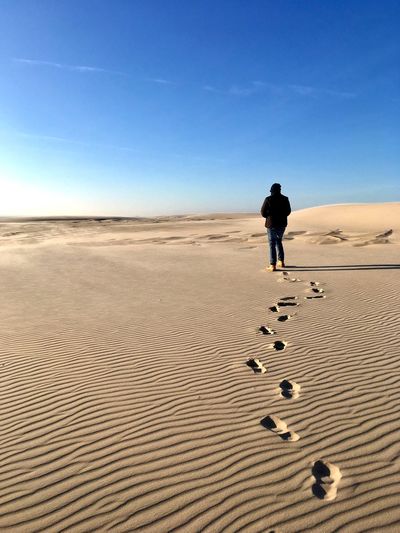 Full length of man walking on sand in desert