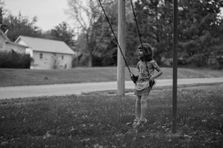 Girl sitting on swing at playground