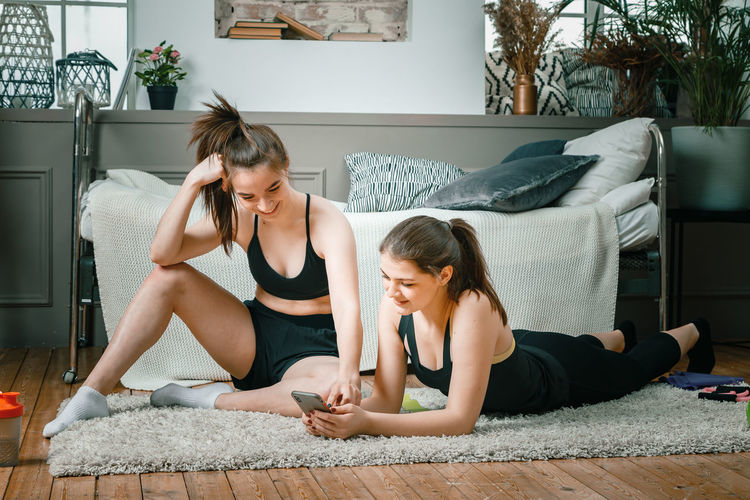 Two athletes are stretching, meditating, discussing workout 