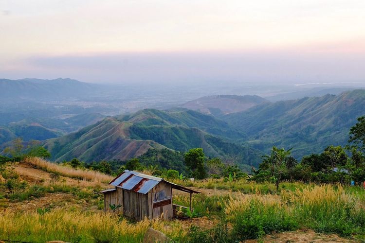 Hut on green mountains against sky