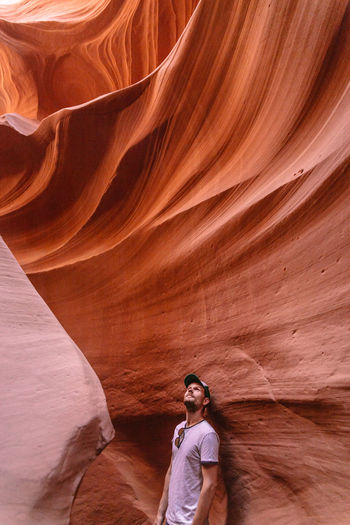 Man standing by rock formation at antelope canyon