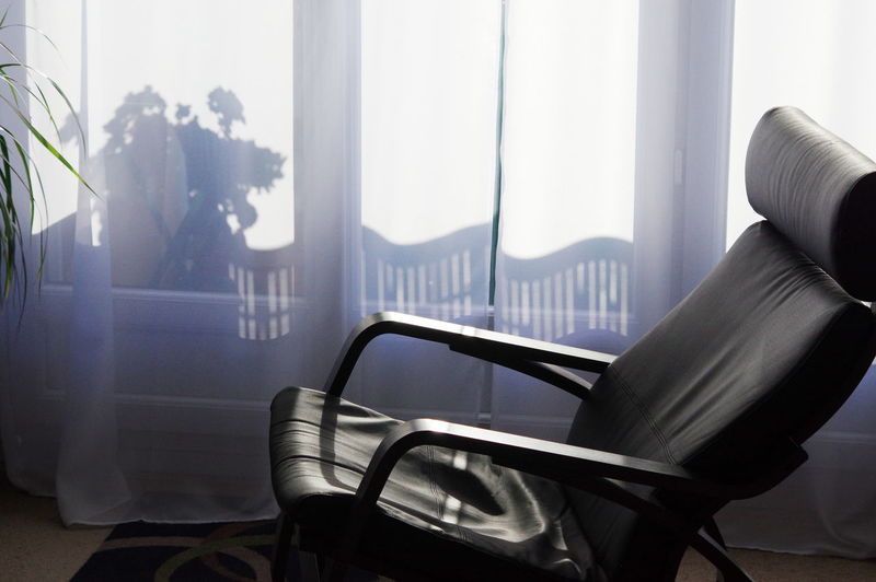 Close-up of chair against window at home