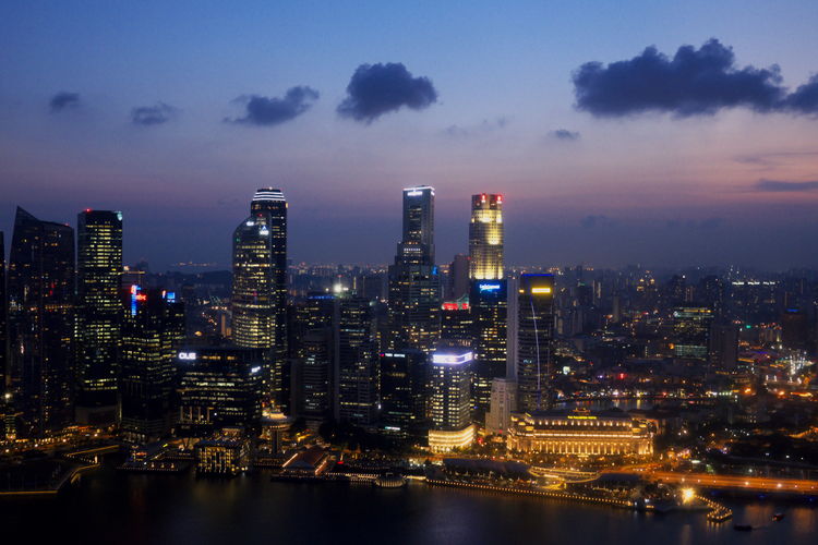 Illuminated buildings in city against sky at night