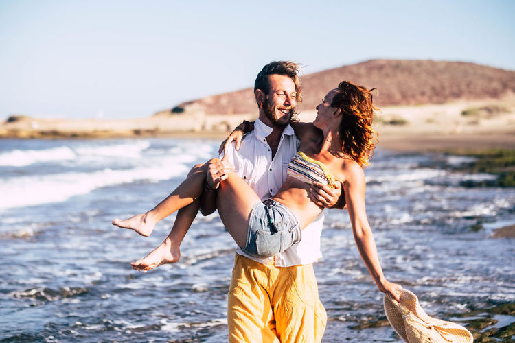 Husband lifting woman while standing at office