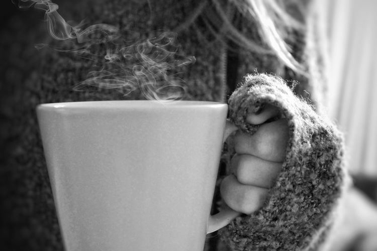 Cropped hand of woman holding coffee cup