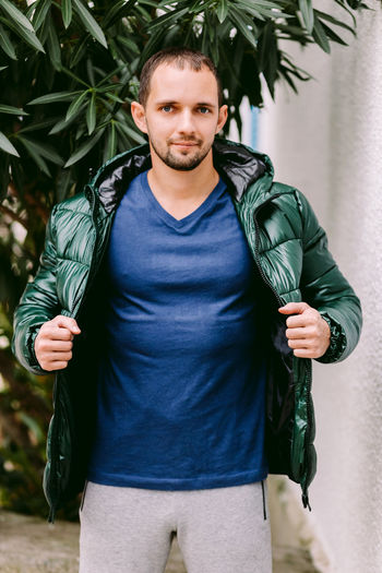 Portrait of man wearing jacket standing outdoors