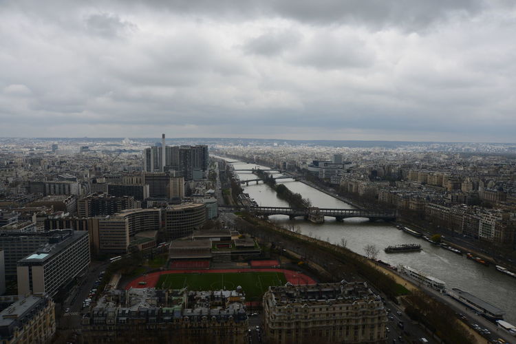 High angle view of seine river in city against cloudy sky