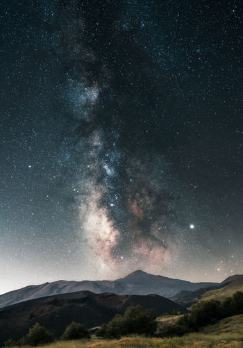 Low angle view of mountains against sky at night