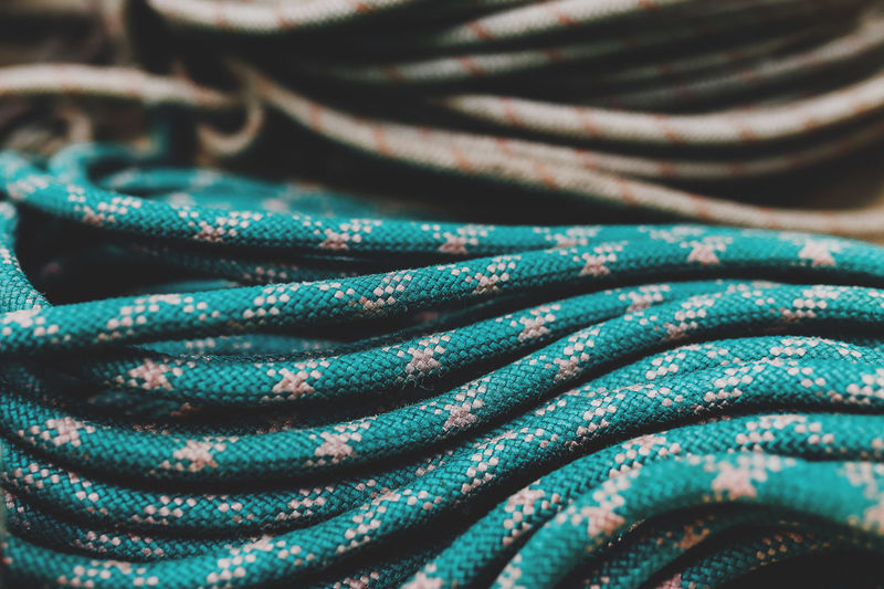 Green white nylon rope is coiled in a pile at a fishing port. stack of knotted marine rope. high