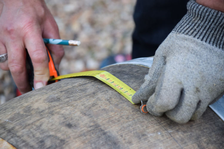 Cropped image of worker working on wood with tools