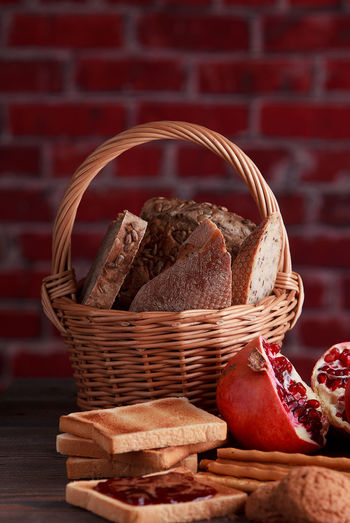 Different buns of fresh bread and spikelets of wheat on a brown vintage background