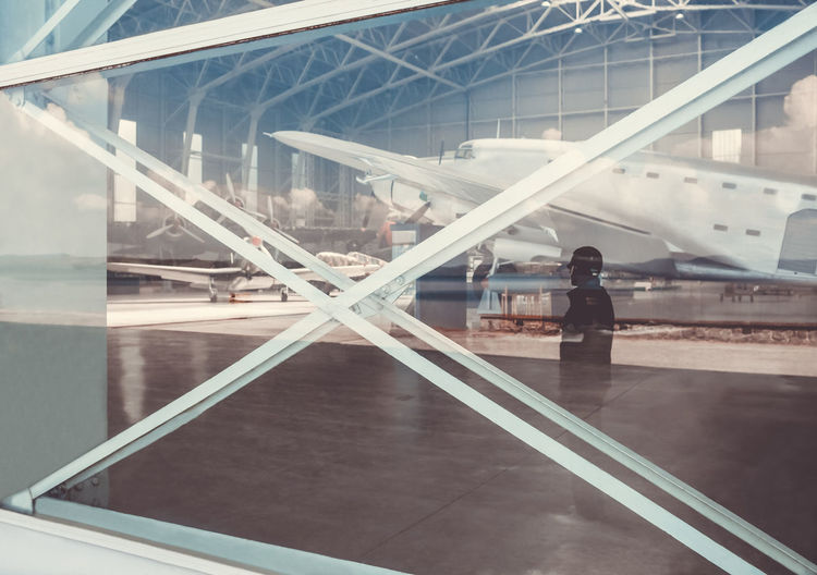 Reflection of man on window at airport