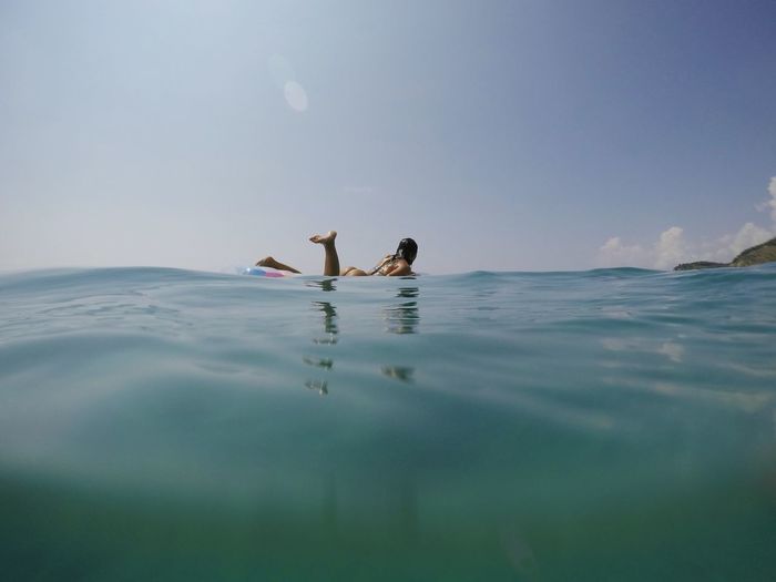 Full length of woman swimming in sea against sky