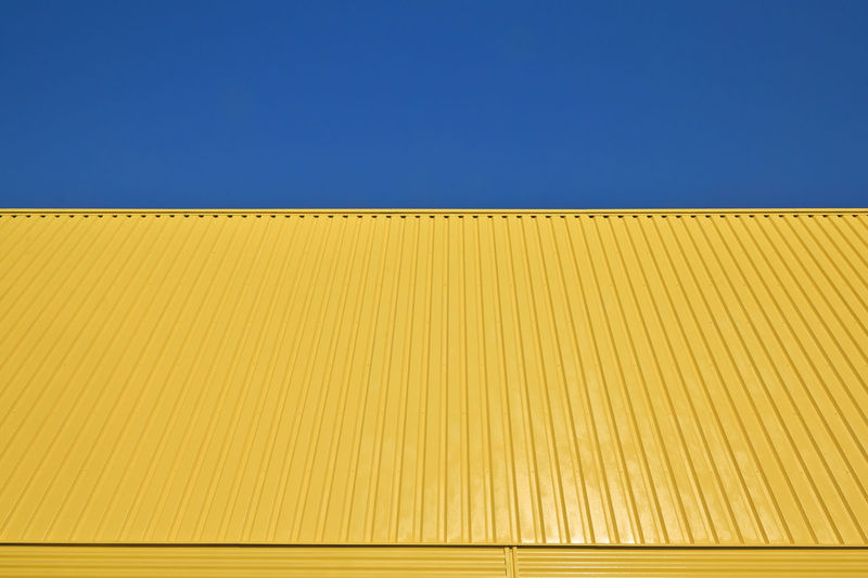 Background pattern yellow galvanized metal profile against the sky