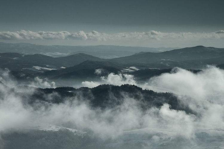 Scenic view of cloud covered mountains against sky