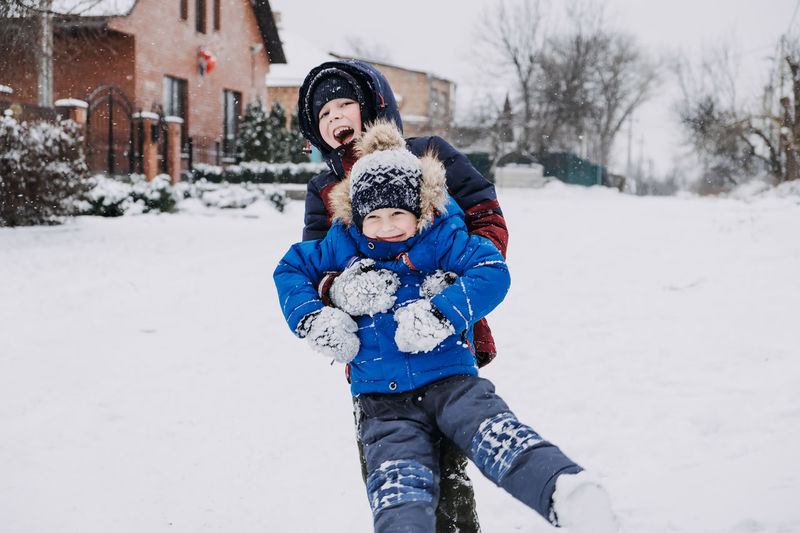 Outdoor winter activities for kids. kids playing in the suburbs, winter backyard gathering. boys 