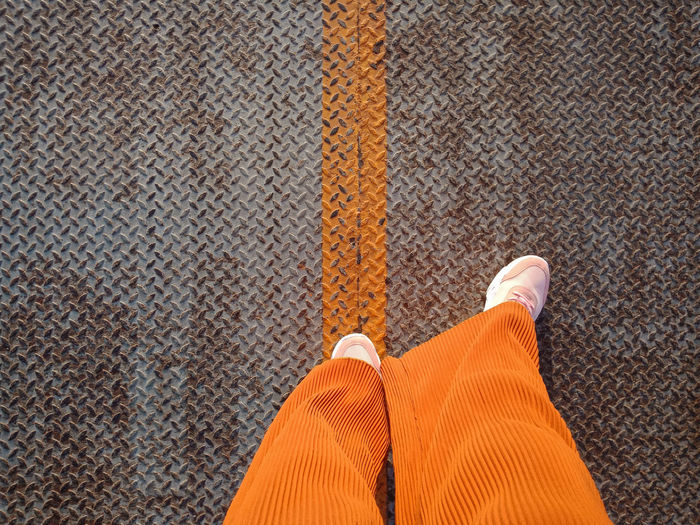 Low section of woman walking on sheet metal