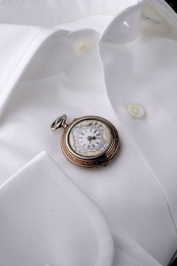 High angle view of pocket watch on shirt