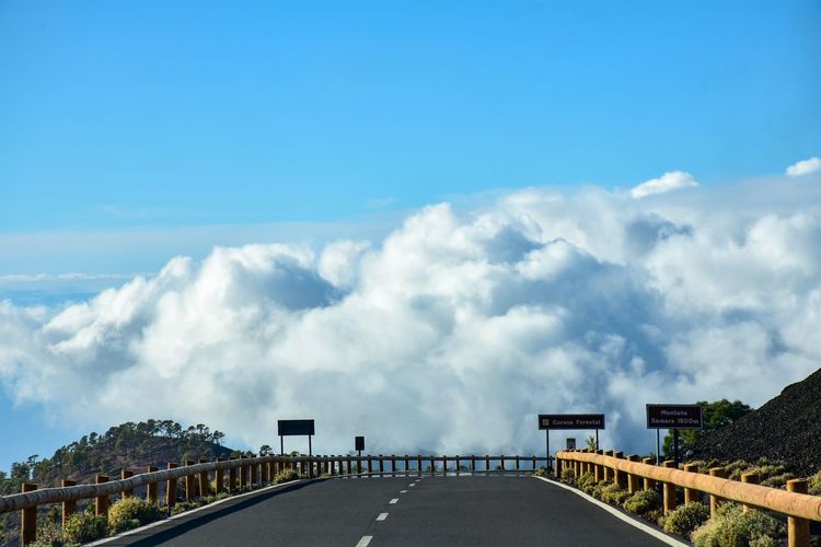 Road leading towards bridge against sky