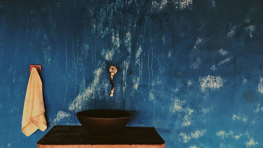 Close-up of sink below faucet on blue wall